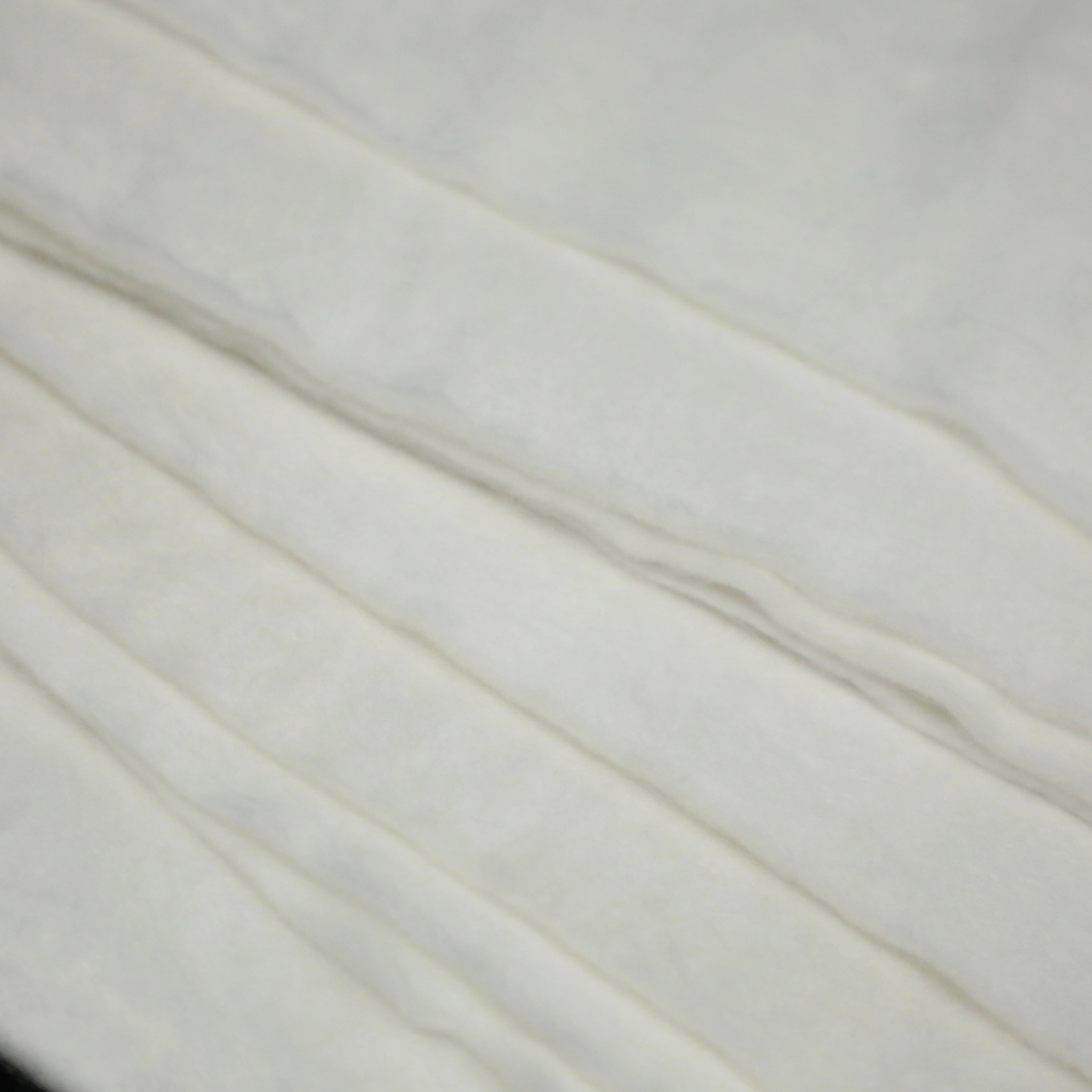 Surface texture of spunbond needle-punched nonwoven geotextile, highlighting consistent fiber alignment and anti-vibration friction properties