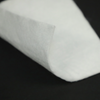 White polypropylene nonwoven filament geotextile close-up, showing uniform fiber structure and edge detail for civil engineering applications